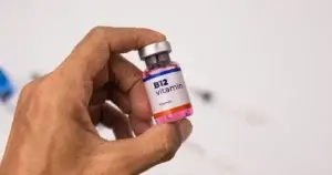 Hand holding a vial of Vitamin B12 injection fluid, relevant to B12 Injections in Corpus Christi, TX.