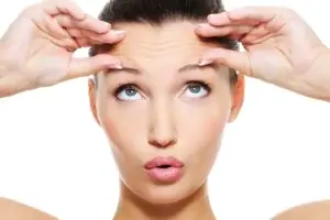 Woman examining forehead wrinkles expression